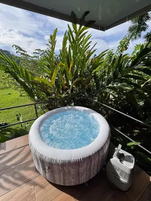 a large bath tub sitting on a wooden deck at Cabaña privada cerca de Manuel Antonio in Parrita