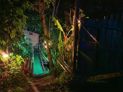 a garden at night with a fence and lights at Tipi Bribri in Heredia