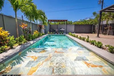 a swimming pool in a backyard with palm trees at Casa Encanto Potrero, Flamingo in Liberia