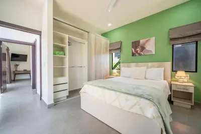 a green bedroom with a bed and a tv at Casa Encanto Potrero, Flamingo in Liberia