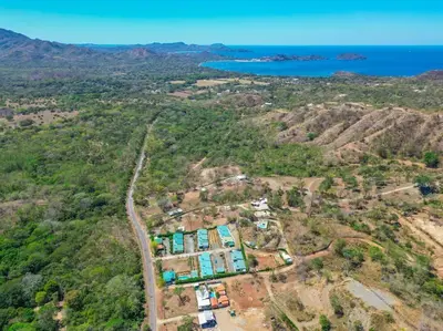 an aerial view of a house on a hill next to the ocean at Casa Encanto Potrero, Flamingo in Liberia