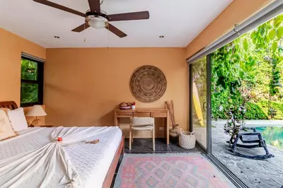 a bedroom with a bed and a desk with a ceiling fan at VIP La Lora Beach Villa best family home in Santa Teresa Beach