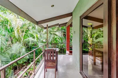 an indoor balcony of a house with palm trees at VIP La Lora Beach Villa best family home in Santa Teresa Beach