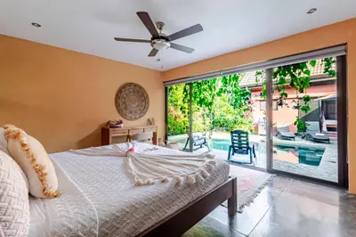 a bedroom with a bed and a large sliding glass door at VIP La Lora Beach Villa best family home in Santa Teresa Beach