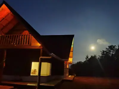a house at night with the moon in the sky at Casa Roble Cabaña romántica en la montaña de Costa Rica in San Cristóbal Sur