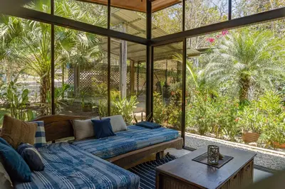 a screened in porch with a bed and a table at Casa Cabo Blanco Mal Pais in Carmen