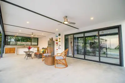 a living room with a ceiling fan and windows at Ocean and Jungle views! AC, Wi-Fi, kitchen in Manzanillo