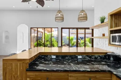 an aquarium in the middle of a kitchen with windows at Modern Home with Chic Bohemian Style and Zen Outdoor Oasis with Swimming Pool and Tiki Style Dining Space in Potrero
