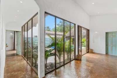 an empty room with large windows and a view of the ocean at Modern Home with Chic Bohemian Style and Zen Outdoor Oasis with Swimming Pool and Tiki Style Dining Space in Potrero