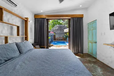 a bedroom with a bed and a view of a pool at Modern Home with Chic Bohemian Style and Zen Outdoor Oasis with Swimming Pool and Tiki Style Dining Space in Potrero