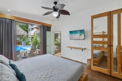 a bedroom with a bed and a view of a pool at Modern Home with Chic Bohemian Style and Zen Outdoor Oasis with Swimming Pool and Tiki Style Dining Space in Potrero