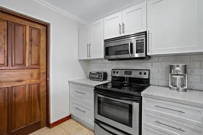 a kitchen with a stove and a microwave at Stylish Flamingo Condo with Ocean Views, Renovated Kitchen & Walkable Beach Access in Playa Flamingo