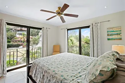 a bedroom with a bed and a balcony at Stylish Flamingo Condo with Ocean Views, Renovated Kitchen & Walkable Beach Access in Playa Flamingo