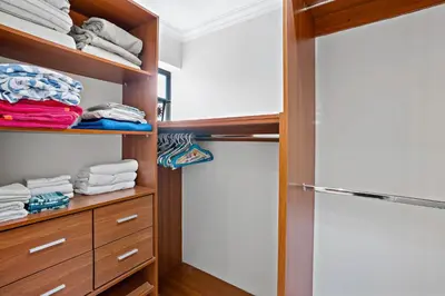 a walk in closet with wooden shelves and towels at Stylish Flamingo Condo with Ocean Views, Renovated Kitchen & Walkable Beach Access in Playa Flamingo