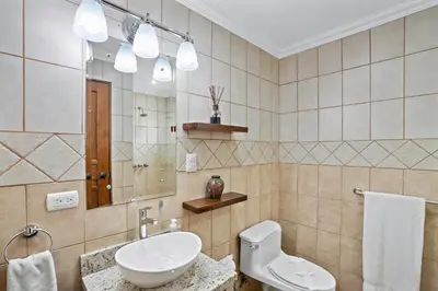a bathroom with a sink and a toilet and a mirror at Stylish Flamingo Condo with Ocean Views, Renovated Kitchen & Walkable Beach Access in Playa Flamingo