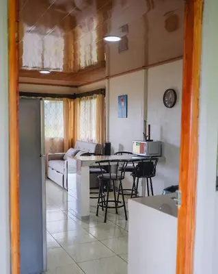 a kitchen and living room with a table and a couch at Casa Paraíso - La Fortuna in Fortuna