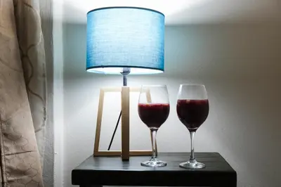 two wine glasses sitting on a table with a lamp at Casa Paraíso - La Fortuna in Fortuna