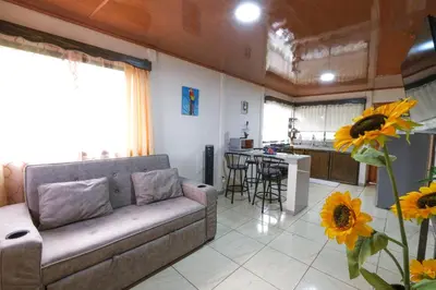 a living room with a couch and a kitchen at Casa Paraíso - La Fortuna in Fortuna