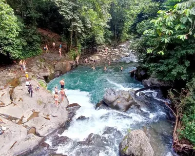 a group of people swimming in a river at Casa Paraíso - La Fortuna in Fortuna