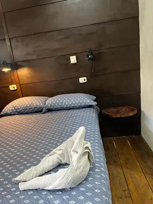 a bed with a blanket on it in a room at Cabañas MOHE’S Uvita in Uvita