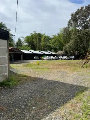 a building with cars parked in a parking lot at Cabañas MOHE’S Uvita in Uvita