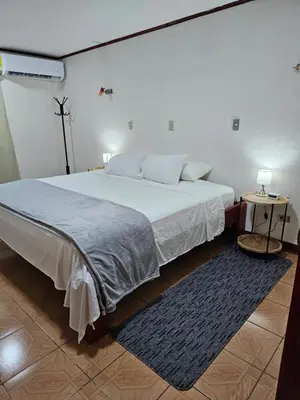 a bedroom with a large white bed and a table at Casa Naboo in Santa Cruz