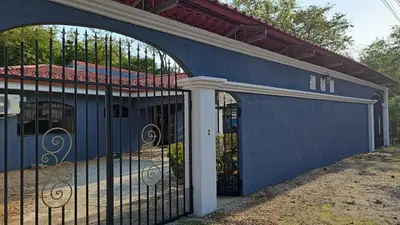 a blue building with a gate and a house at Casa Naboo in Santa Cruz