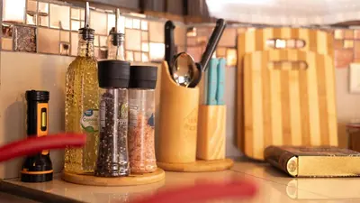 a counter with several bottles of spices and a book at The Toucan Nest - AC, Gated & Pool in Fortuna