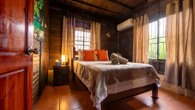 a bedroom with a bed in a wooden room at The Toucan Nest - AC, Gated & Pool in Fortuna