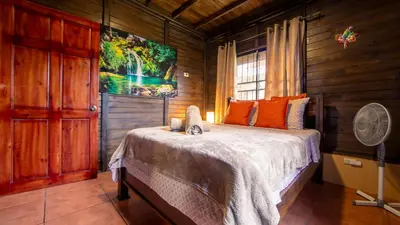 a bedroom with a bed and a fan in a room at The Toucan Nest - AC, Gated & Pool in Fortuna