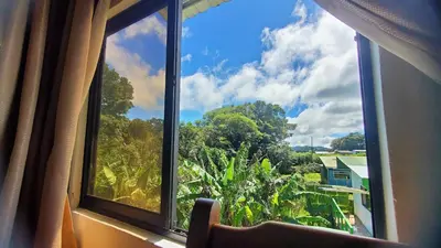 a window with a view of trees and a house at Grand Luna - Monteverde in Tilarán