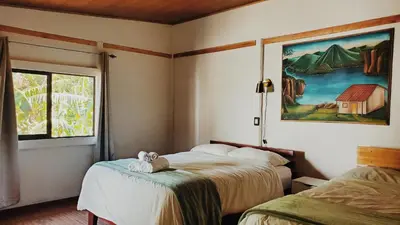 a bedroom with two beds and a painting on the wall at Grand Luna - Monteverde in Tilarán