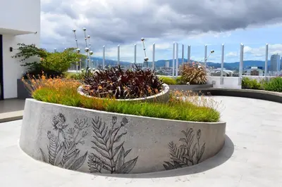a concrete planter with plants in it on a building at Apartamento con piscina y espacio de trabajo in San José