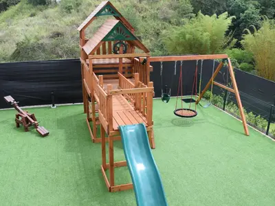 a playground with a slide and a swing at Apartamento con piscina y espacio de trabajo in San José