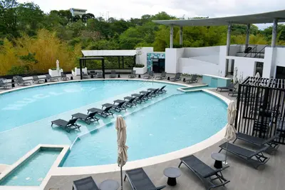 a large swimming pool with chaise lounge chairs at Apartamento con piscina y espacio de trabajo in San José
