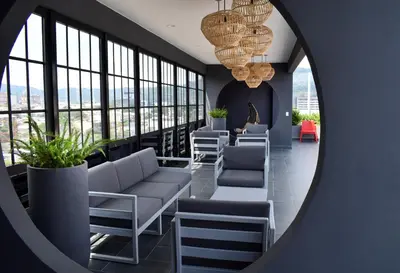 a room with couches and chairs and windows at Apartamento con piscina y espacio de trabajo in San José
