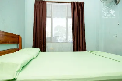 a large bed in a bedroom with a window at Manuel Antonio Hostel in Manuel Antonio