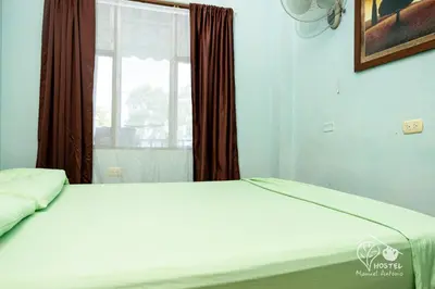 a bed in a room with a window at Manuel Antonio Hostel in Manuel Antonio