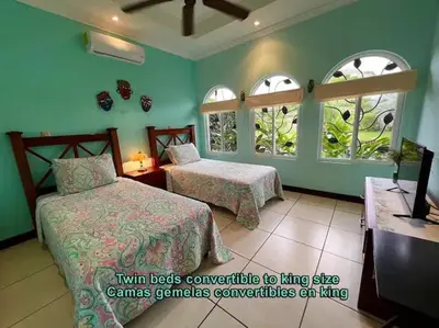 a bedroom with two beds and two windows at Villa Almería by Vacation Pura Vida in Bejuco
