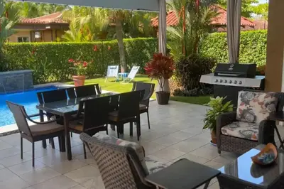 a patio with a table and chairs and a pool at Villa Almería by Vacation Pura Vida in Bejuco