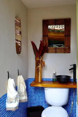 a bathroom with a toilet with a sink and a mirror at Villa Encantada by Vacation Pura Vida in Esterillos