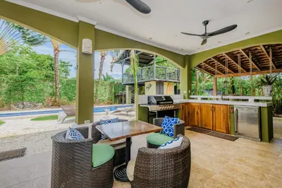 an outdoor kitchen with a table and chairs at Villa Encantada by Vacation Pura Vida in Esterillos