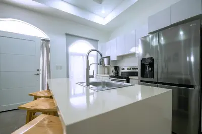 a white kitchen with a sink and a refrigerator at Villa Isabella by Vacation Pura Vida in Esterillos