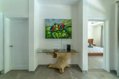 a room with a table with two parrots on the wall at Villa Isabella by Vacation Pura Vida in Esterillos