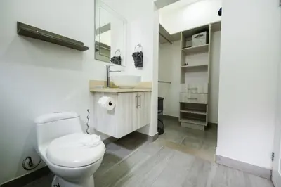 a bathroom with a white toilet and a sink at Villa Isabella by Vacation Pura Vida in Esterillos