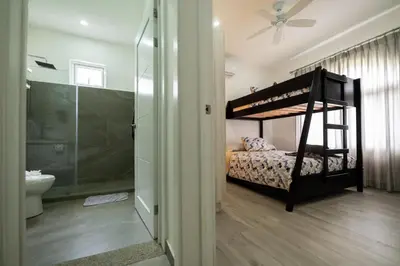 a bedroom with a bunk bed and a bathroom at Villa Isabella by Vacation Pura Vida in Esterillos