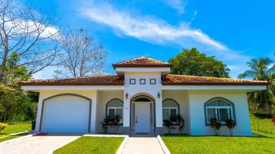 a small white house with a garage at Villa Isabella by Vacation Pura Vida in Esterillos