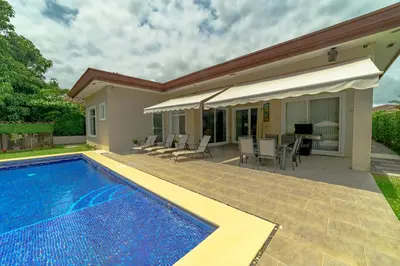 a house with a swimming pool and a patio at Villa Jardin by Vacation Pura Vida in Esterillos