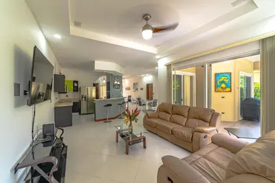 a living room with a couch and a tv at Villa Jardin by Vacation Pura Vida in Esterillos