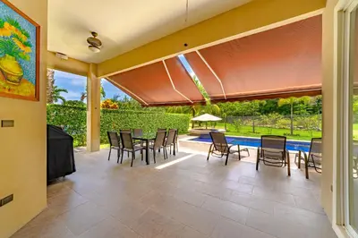 a patio with a table and chairs and a pool at Villa Jardin by Vacation Pura Vida in Esterillos